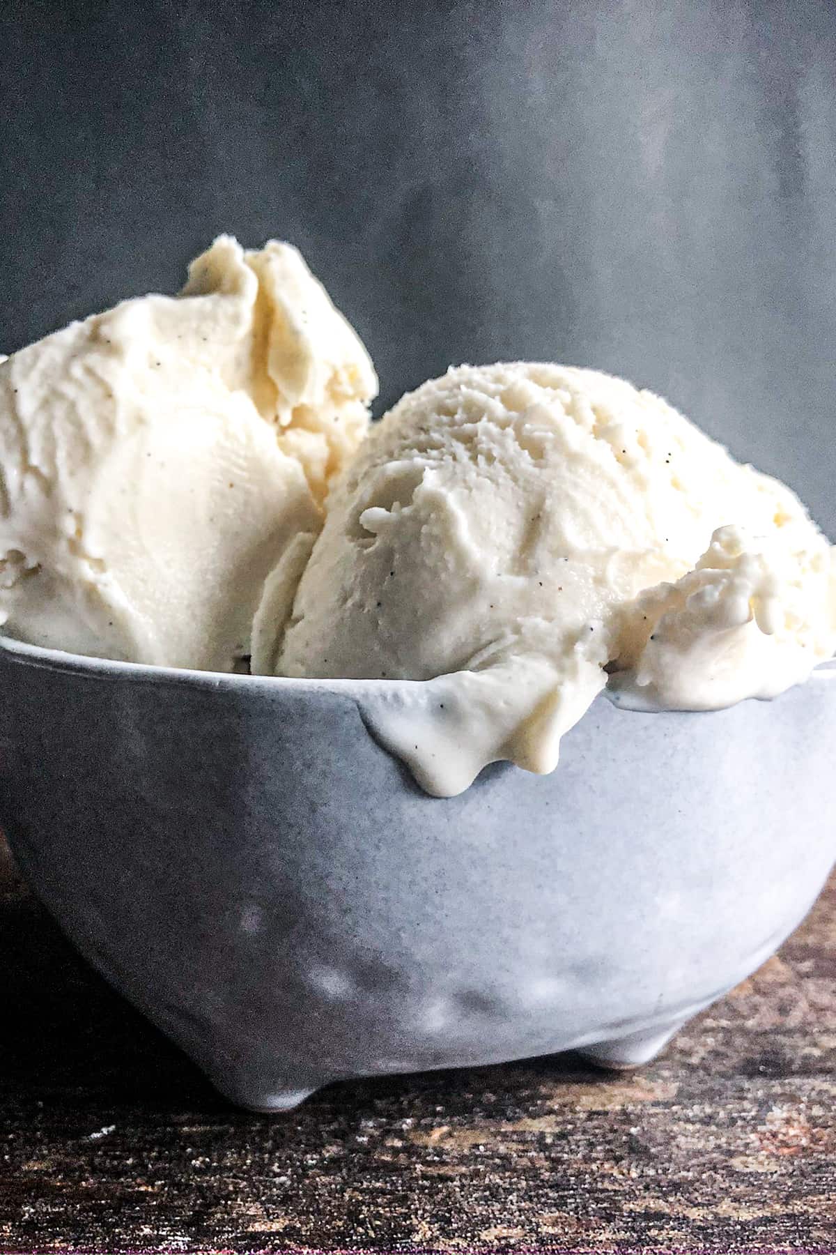 Vanilla bean ice cream in a blue bowl.