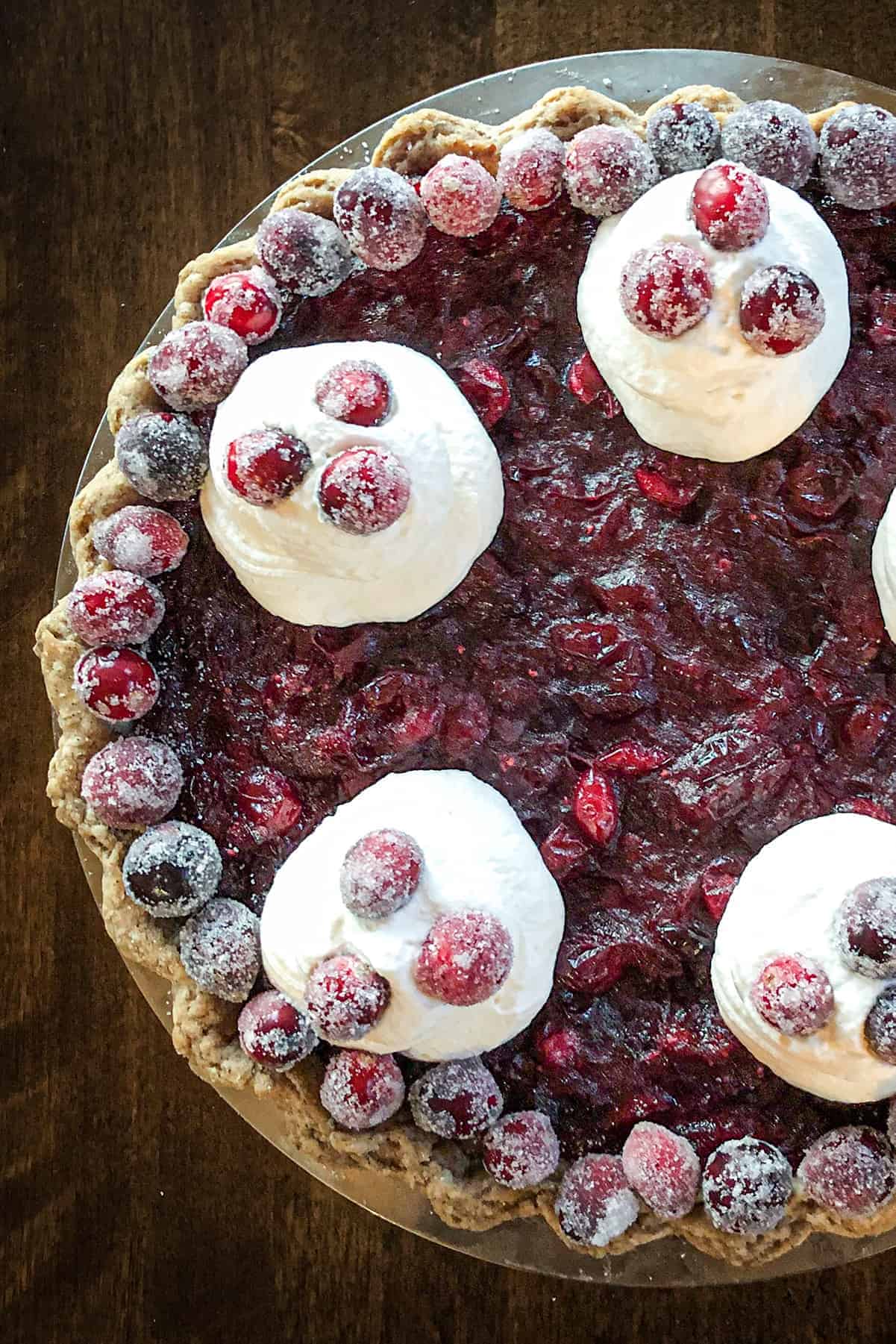 Cranberry custard pie with whipped cream from the top.