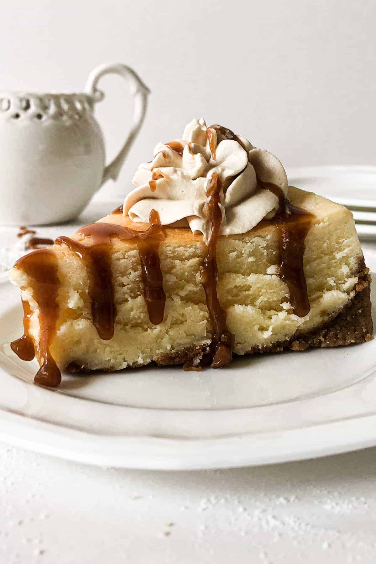 New York cheesecake with whipped cream and salted caramel drizzle.